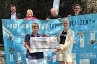 Über die 1.032 € der Banner-Versteigerung freuen sich (v. h. l.) Bürgermeister Ulrich Berger, Monika Werner (Stadt Salzkotten), Dietmar Schaudt (Vorstand Speisenkammer) und Graffiti-Sprayer Lukas Michalski (Vorstand der Paderborner Kreaturen) sowie (v. v. l.) Jutta Schnieders (Vorstand Speisenkammer) und Modemacherin Laura Schlütz (Vorstand der Paderborner Kreaturen)