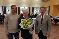 Das Foto zeigt drei Männer. Links steht das neue Ratsmitglied der Stadt Salzkotten, Andre Bertelsmeier, in der Mitte steht Theo Flottmeier, der einen Blumenstrauß in der Hand hält, und rechts daneben steht Bürgermeister Ulrich Berger