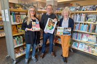 Das Foto zeigt drei Personen, die in der Stadtbibliothek vor einem Bücherregal stehen. Es handelt sich um Beatrix Stuckenbröker (Mitglied des Stifterrates der Bürgerstiftung Salzkotten), Reinhard Kamp (2. Vorsitzender der Bürgerstiftung Salzkotten) und Maria Breuer (Leiterin der Stadtbibliothek). 
