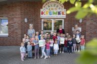 Das Foto zeigt eine Gruppe aus Kindern und drei Frauen vor dem Eingang der Kindertagesstätte &quot;Sälzerkrümel&quot;