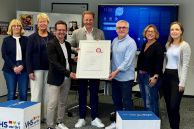 Vier Frauen und drei Männer stehen im Schulungsraum der VHS in Salzkotten. Sie halten das Zertifikat zur Rezertifizierung in den Händen.