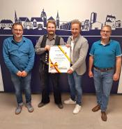 Bürgermeister Ulrich Berger (Mitte rechts) überreicht zusammen mit Martin Westermeier (rechts, Fachbereichsleiter Stadtentwicklung) und Sam Seyfzadeh (links, Klimaschutz- und Mobilitätsmanager) die Urkunde für den 1.000 Förderantrag im Rahmen des städtischen Förderprogramms Klimaschutz & Klimafolgeanpassungen an Henrik Hüttemann (Mitte links, Antragssteller)