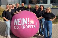 Neun Frauen, bei denen es sich um die Gleichstellungsbeauftragten der Kommunen aus dem Kreis Paderborn handelt, stehen um einen großen pinken Ball, auf dem &quot;NEIN! zu K.O.-Tropfen steht. 