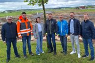 Die Verantwortlichen der Stadt Salzkotten vor dem erschlossenen Baugebiet „Osterfeld“ (v. l.): Thomas Dresbur (Stv. Betriebsleiter Stadtwerke), David Kirchhoff (Stv. Fachbereichsleiter Stadtentwicklung), Juliane Kruse (Fachdienst Bauleitplanung), Bürgermeister Ulrich Berger, Martin Westermeier (Fachbereichsleiter Stadtentwicklung), Peter Finke (Wirtschaftsförderer) und Christian Hübner (Wirtschaftsförderung & Flächenmanagement). Alle stehen vor dem Baugebiet auf einer Wiese mit Baum.