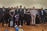 Die Schulleitung und Sponsoren stehen mit den Preisträgerinnen und Preisträgern zusammen und halten ihre Geschenke in den Händen.