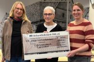 Vor der Theke der Bücherausleihe in der Stadtbibliothek Salzkotten stehen die Vorsitzende des Fördervereins der Stadtbibliothek, die Vorsitzende der Speisenkammer Salzkotten und die Leiterin der Stadtbibliothek Salzkotten.