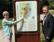 Elisabeth Kloke-Kemper (Vorsitzende Verein Judentum in Salzkotten e. V.) und Bürgermeister Ulrich Berger stehen neben der neuen Stele, die auf den ältesten jüdischen Friedhof in Salzkotten hinweist