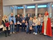 Bürgermeister Ulrich Berger (links neben dem Nikolaus), der Nikolaus und die Mitarbeitenden vom Fachbereich Bildung & Soziales warten im Ratssaal auf die Familien