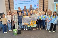 Bildzeile: Anja Ernesti (NABU BNE Regionalzentrum, hinten links), Marcus Foerster (NABU BNE Regionalzentrum, hinten rechts) und Sam Seyfzadeh (Klimaschutz- und Mobilitätsmanager, hinten mittig) zusammen mit den Projektgruppen der beteiligten Schulen; gemeinsam im Ratssaal stehend