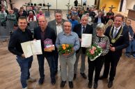 Die Preisträger, Bürgermeister Ulrich Berger und der Vorsitzende des Kultur- und Sportausschusses stehen nebeneinander in der Mensa der Gesamtschule Salzkotten. Die Preisträger halten ihre Urkunden in den Händen.