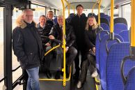 Sechs Personen sitzen in einem Bus und schauen zum Fotografen