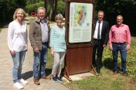 Fünf Personen stehen im Franz-Kleine-Park in Salzkotten vor einer neuen Stele. Die Stele hat eine rot-rostige Halterung. Auf einer davor montierten und bedruckten Hinweistafel sind Angaben zum ältesten jüdischen Friedhof in Salzkotten abgebildet.