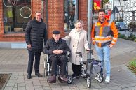 Bürgermeister Ulrich Berger, die Eheleute Roeßler und David Kirchhoff stehen an der Kreuzung vor einem frisch abgesenkten Bordstein.