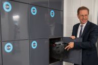 Bürgermeister Ulrich Berger testet die neuen Schließfächer, indem er einen Fahrradhelm in ein Schließfach legt.