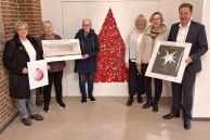 Die Initiatorinnen, die Vorsitzende der Speisenkammer Salzkotten und Bürgermeister Ulrich Berger stehen im Foyer des Rathauses vor einem roten Weihnachtsbaum, der im Rahmen der Aktion "Früher war mehr Lametta" entstanden ist.