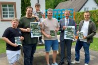 Paul Paus (l.) und Lukas Olschewski (3. v.l.) freuen sich zusammen mit (v.l.) Simon Keuer (Mitarbeiter Jube), Fabian Dirks (Fachdienst Jugend, Kultur & Sport), Bürgermeister Ulrich Berger und René Scherf (Ausschussvorsitzender Jugend-, Kultur- & Sportausschuss) auf die Ferien.
