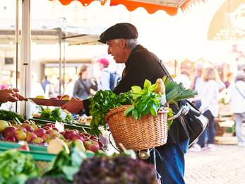 Mann kauft auf dem Wochenmarkt ein