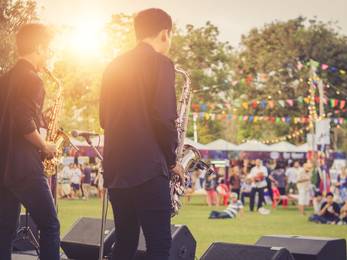 Jazz-Musiker auf einer Outdoor-Bühne mit Publikum im Hintergrund