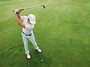 Ein Golfspieler beim Abschlagen von oben